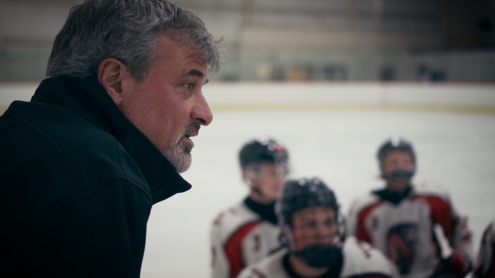 A coach addressing players on the bench